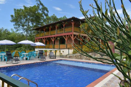 蒙特内哥罗Finca Hotel Villa Mariana的大楼前带游泳池的房子