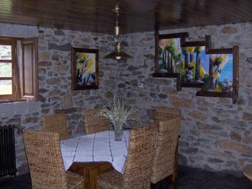 维米欧索Casa da Janal的一间设有桌椅和石墙的用餐室