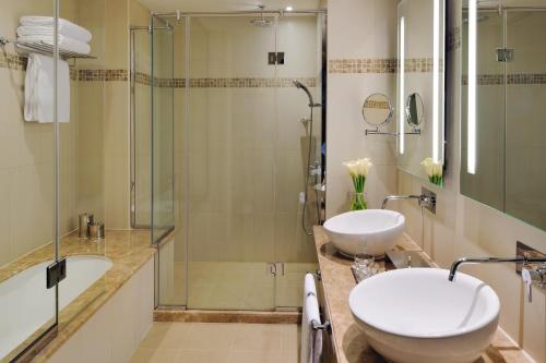 迪拜Avani Deira Dubai Hotel的一间带两个盥洗盆和淋浴的浴室