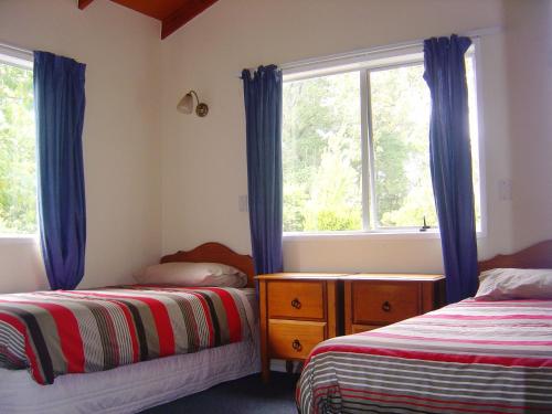 Tuai欧胡卡度假屋的一间卧室设有两张床和窗户。