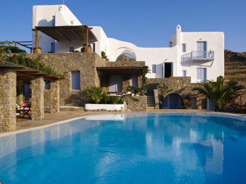 超级天堂海滩那玛别墅酒店的一座大蓝色游泳池,位于房子前
