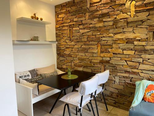 贝伦埃斯科巴Estudio的一间设有石墙和桌椅的用餐室