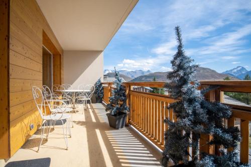 于埃Superb apartment with balcony in the heart of Huez - Welkeys的阳台配有桌椅和圣诞树。