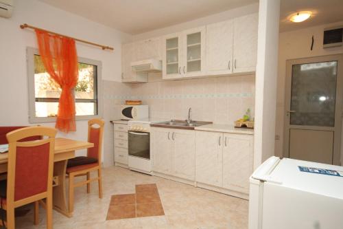 拉斯托伏Apartments by the sea Pasadur, Lastovo - 8391的厨房配有白色橱柜、桌子和水槽。