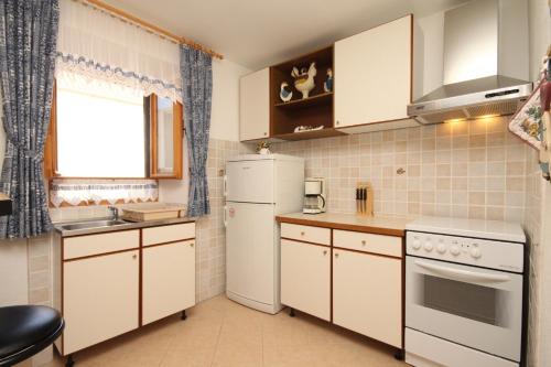 萨利Apartments with a parking space Sali, Dugi otok - 8084的一间小厨房,配有白色家电和窗户