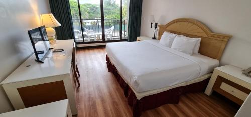 塔穆宁SureStay Hotel by Best Western Guam Airport South的酒店客房设有一张床和一个阳台。