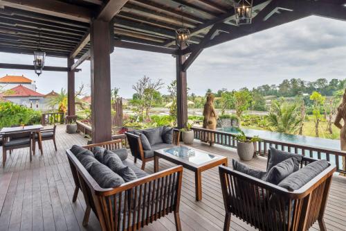 海神庙Royal Roco Villa的室外庭院配有桌椅,享有水景。