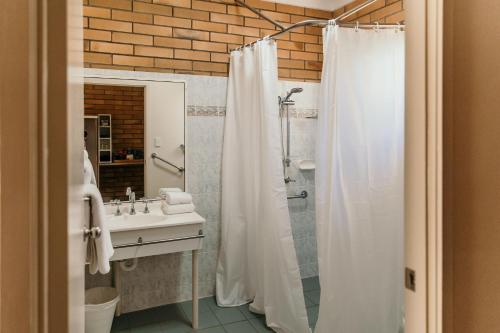 布莱克尔Oasis Motor Inn Blackall的浴室配有淋浴帘和盥洗盆。