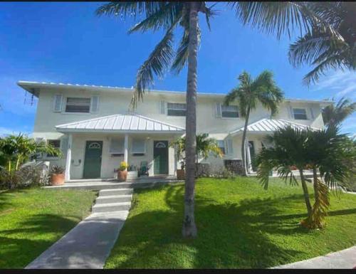 普罗维登西亚莱斯岛SeaSide Townhome, Spacious 2br 3bath Leeward Grace Bay, Providenciales, walk to beach的一座棕榈树掩映的白色房子