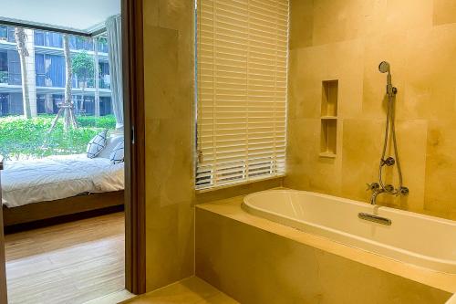 迈考海滩Baan Mai Khao - 2 Bedroom Luxury Condo- Direct Pool & Beach Access的带浴缸、床和窗户的浴室