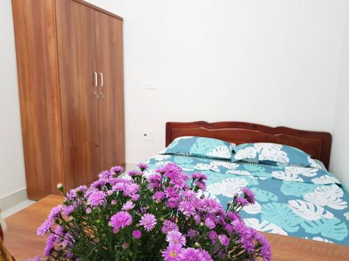 河内Water puppet nest - private and cozy space for you的一间卧室,床上有紫色鲜花
