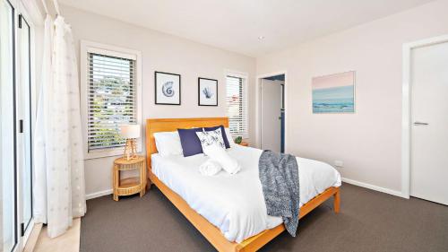 尼尔森湾Dutchmans Bay Escape 45A Thurlow的一间卧室设有一张大床和一个窗户。
