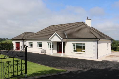 莫纳汉Laneside Haven - Accessible Gated Retreat - 5 Minutes from Castleblayney with Garden & Recreation Room!的黑色屋顶的白色房子