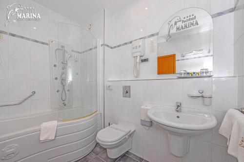 塞尔瑟马里纳酒店的白色的浴室设有浴缸、盥洗盆和卫生间。