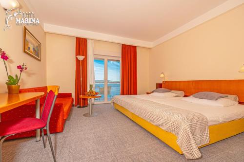 塞尔瑟马里纳酒店的配有一张床、一张书桌和一扇窗户的酒店客房