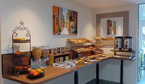 鲁西隆地区卡内Hotel Le Majestic Canet plage的面包店,面包柜台里放满了各种食物