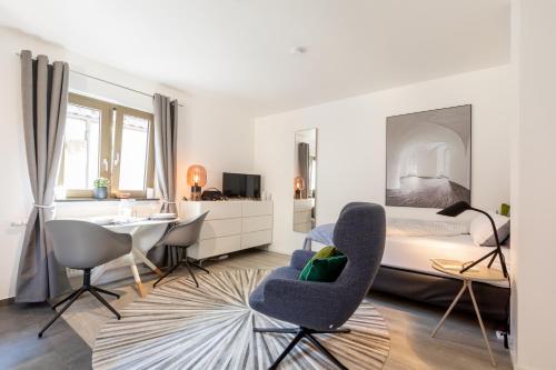 诺伊恩斯塔特阿姆科黑尔Appartement Champagne的卧室配有一张床、一张桌子和椅子