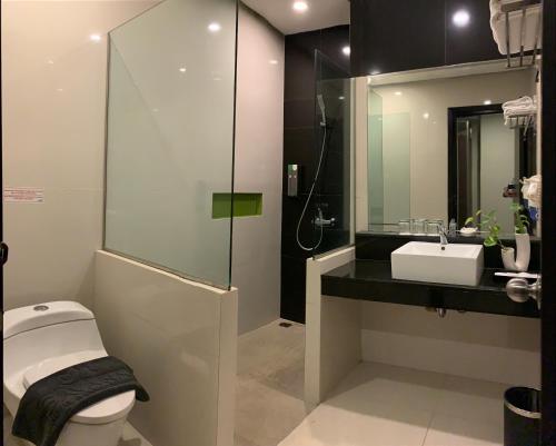 玛琅Savana Hotel & Convention Malang的浴室配有卫生间、盥洗盆和淋浴。