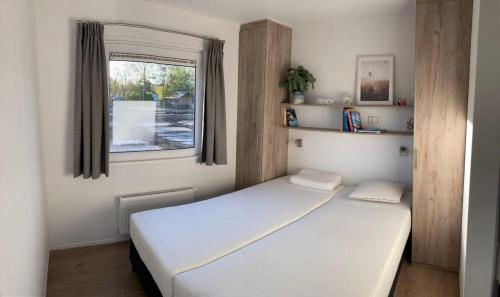 柯德科克Vakantiepark duinzicht的卧室配有白色的床和窗户。