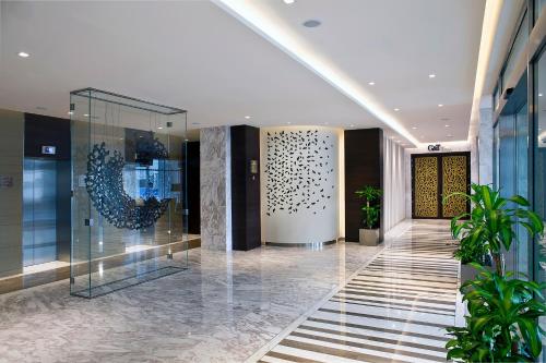 迪拜Grayton Hotel by Blazon Hotels的建筑的大堂,走廊上植有植物