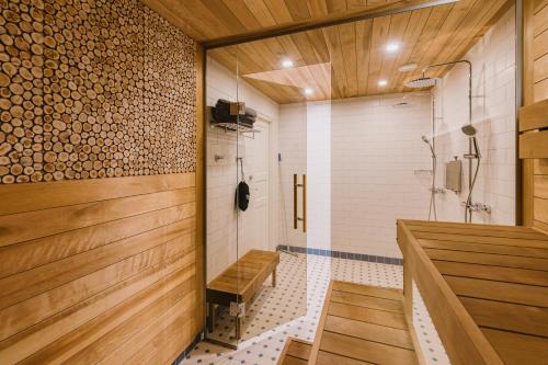 哈普萨卢Villa Fannyhof的带淋浴的浴室和木墙