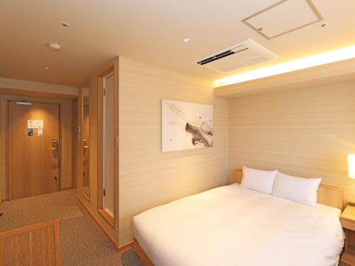 横滨Chisun Inn Yokohama Tsuzuki的卧室配有白色的床