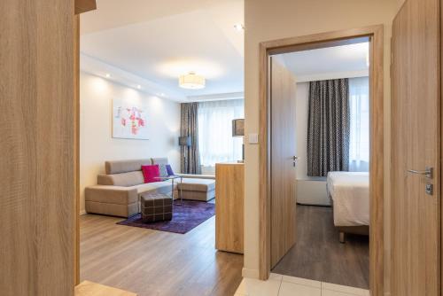 布达佩斯Silver Crown Hotel & Residence, Palace Quarter的酒店客房设有床和客厅。