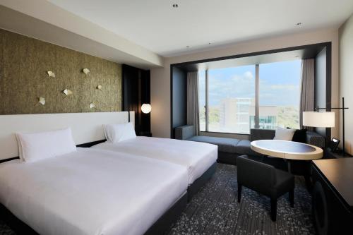 熊本KOKO HOTEL Premier Kumamoto的配有一张床、一张书桌和一扇窗户的酒店客房
