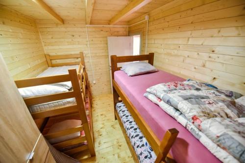 乌尔齐尼Sojenica Tamara的小木屋内一间卧室,配有两张床