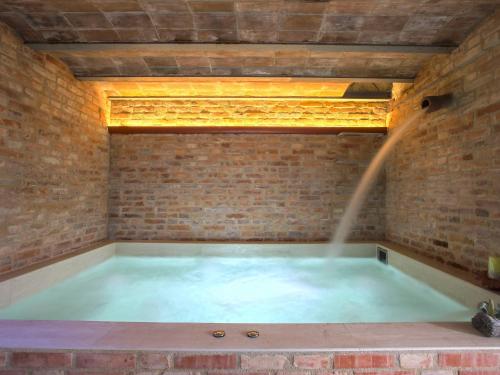 尼阿博勒皮耶韦Apartment Borgo della Limonaia-1 by Interhome的砖墙内带喷泉的浴缸