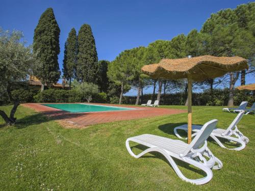 佩萨河谷塔瓦内莱Apartment Campiglia-3 by Interhome的游泳池旁的两把椅子和一把遮阳伞
