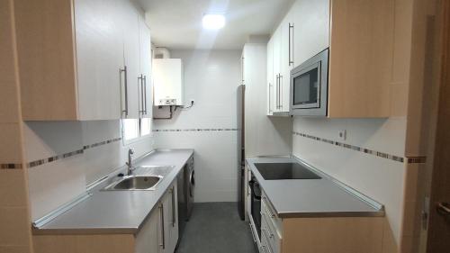 索里亚Los Soportales的厨房配有白色橱柜、水槽和微波炉