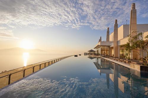 岘港Da Nang Mikazuki Japanese Villas & Spa的游泳池,阳光下在水面上