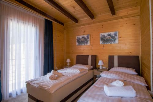 萨拉热窝Villa unforgettable的木墙客房的两张床