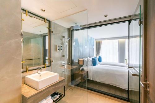 芭堤雅市中心Best Western Plus Nexen Pattaya的浴室设有床、水槽和镜子