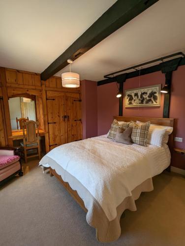CracoeWhittakers Barn Farm Bed and Breakfast的一间卧室配有一张大床和一把椅子