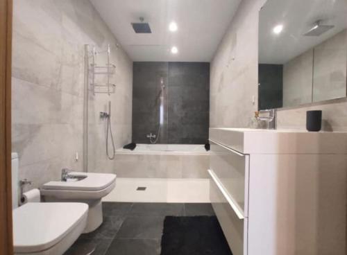 福恩吉罗拉Loft Miramar的浴室配有卫生间、盥洗盆和浴缸。