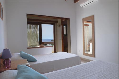 伊维萨镇Hostal Marblau Ibiza的一间白色卧室,配有两张床和窗户