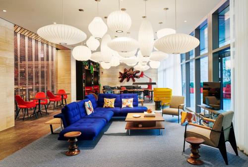 芝加哥citizenM Chicago Downtown的客厅配有蓝色的沙发和桌椅