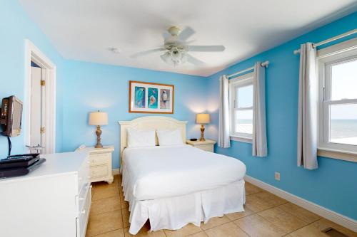 圣乔治岛Beauty And The Beach的卧室配有白色的床和蓝色的墙壁