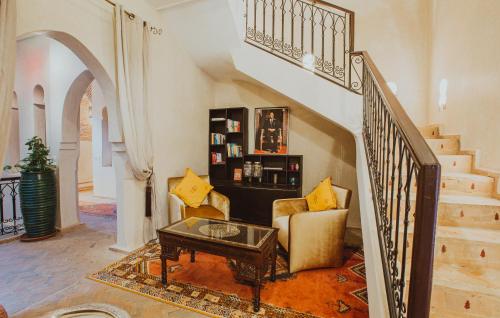 马拉喀什Riad El Hara的带沙发、桌子和楼梯的客厅