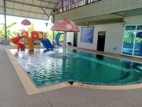 坤西育府Capital O 75412 V Resort的一座带游乐场的建筑中的游泳池