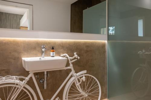 埃斯特雷莫斯Reflexos D'Alma Turismo Rural的一辆停放在带水槽的浴室内的白色自行车