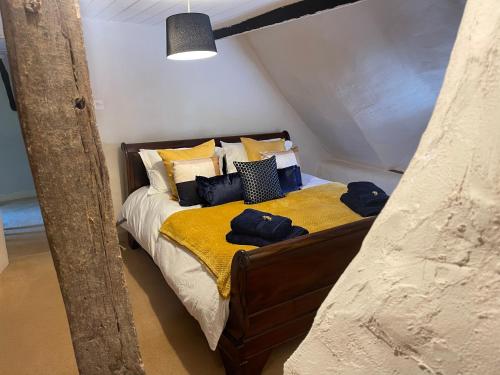 EnfordBeautiful Character Thatched Pet Friendly House的一间卧室配有一张带黄色床单和枕头的床。