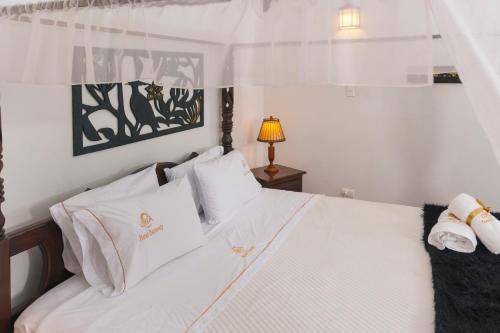 莱瓦镇Hotel Cemandy by MA的卧室配有白色的床单和枕头