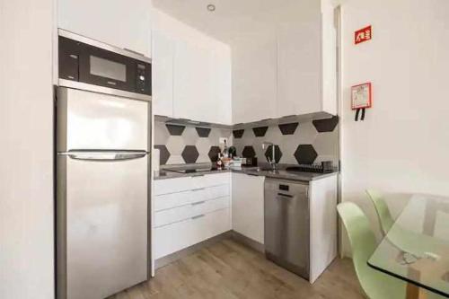 阿玛考德佩拉Timeless Beach III Apartment的厨房配有白色橱柜和不锈钢冰箱