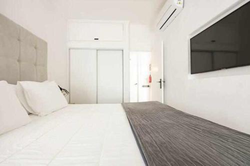 阿玛考德佩拉Timeless Beach III Apartment的白色的客房配有床和平面电视。