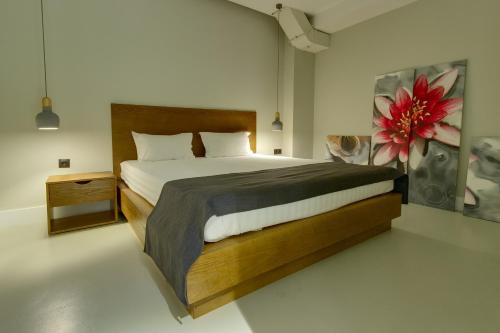 阿拉木图十一厅酒店的一间卧室设有一张大床,墙上挂着一朵花