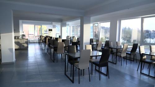 阿哈尔齐赫Aventus Hotel的用餐室设有桌椅和窗户。