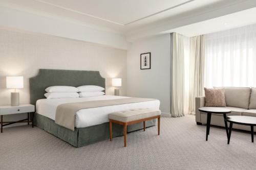 布鲁塞尔Hotel Avenue Louise Brussels Trademark Collection by Wyndham的一间卧室配有一张大床和一张沙发